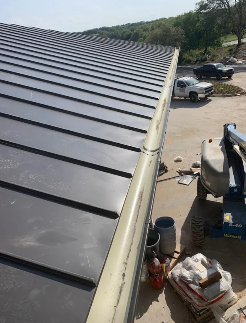 Standing seam panel and gutter detail on a metal roofing jobsite in Edwardsville